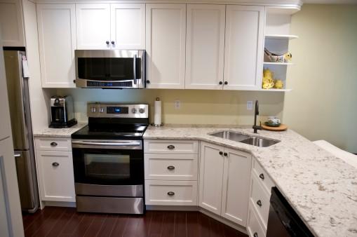 White kitchen with corner sink.